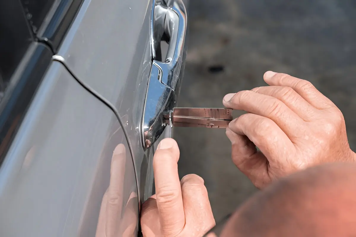 Expert removing a broken key from a car lock safely.